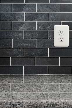 new caledonia granite countertop with black slate subway backsplash tile BA1070