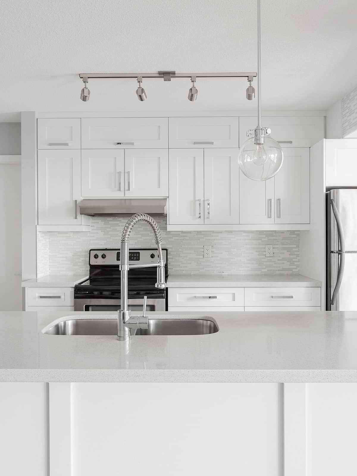 white quartz countertop cabinets with white modern backsplash tile 4