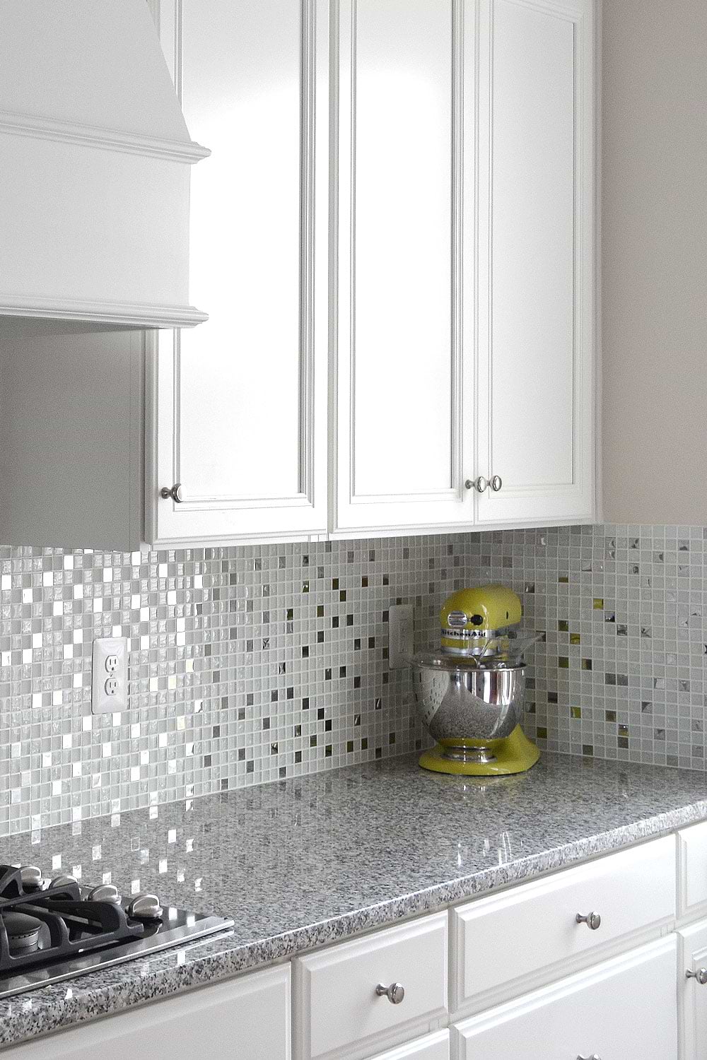White and gray tones, white kitchen cabinets gray Luna Pearl kitchen granite countertop with white glass metal kitchen backsplash tile. #whitebacksplash #whitekitchen #whitecabinet #glassbacksplash #metalbacksplash #modernbacksplash