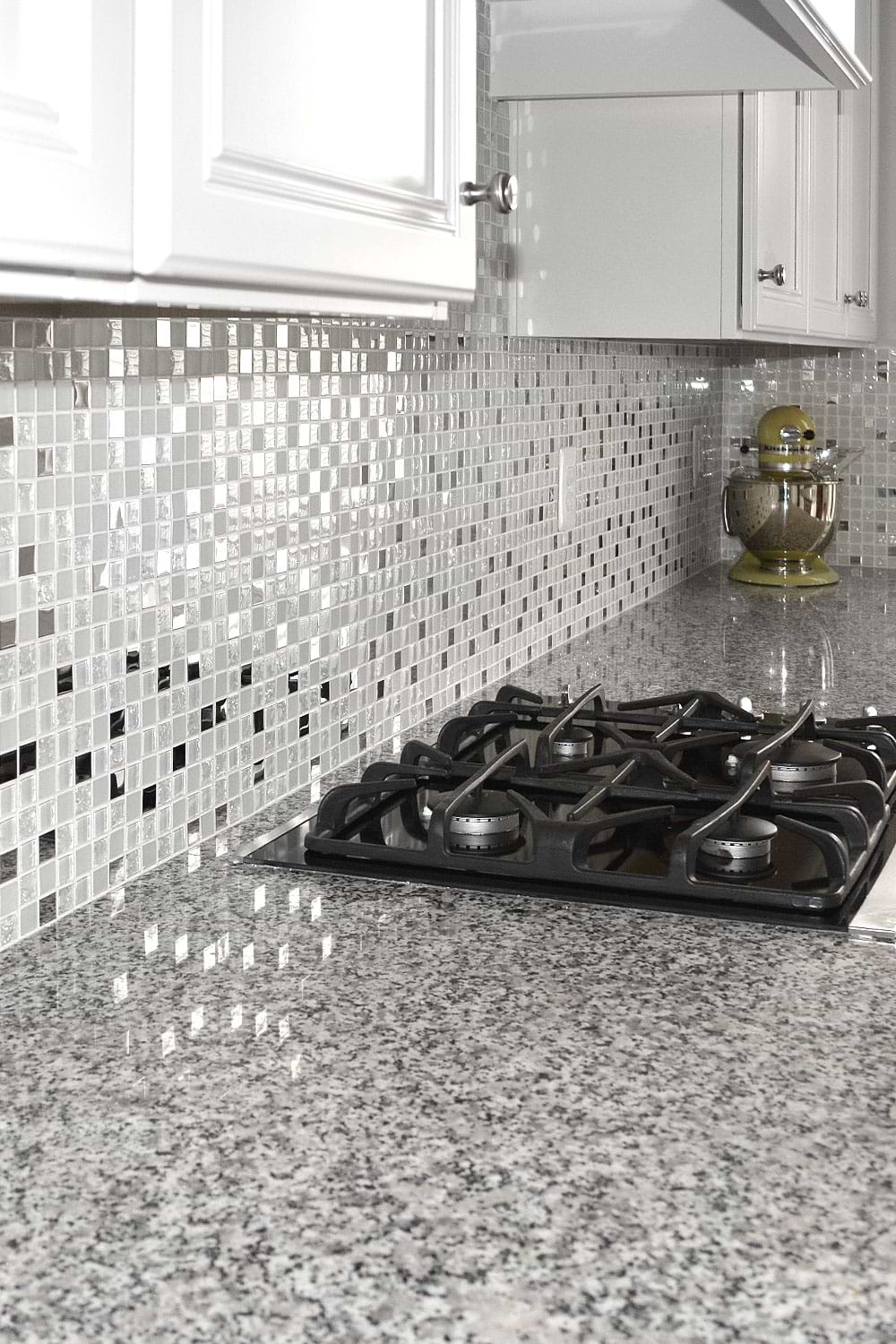 White kitchen cabinets, Luna pearl gray granite countertop with glass and metal mixed backsplash tile. #whitebacksplash #whitekitchen #whitecabinet #glassbacksplash #metalbacksplash #modernbacksplash
