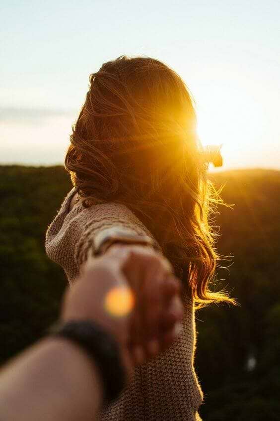 mulher-dando-mao-por-do-sol