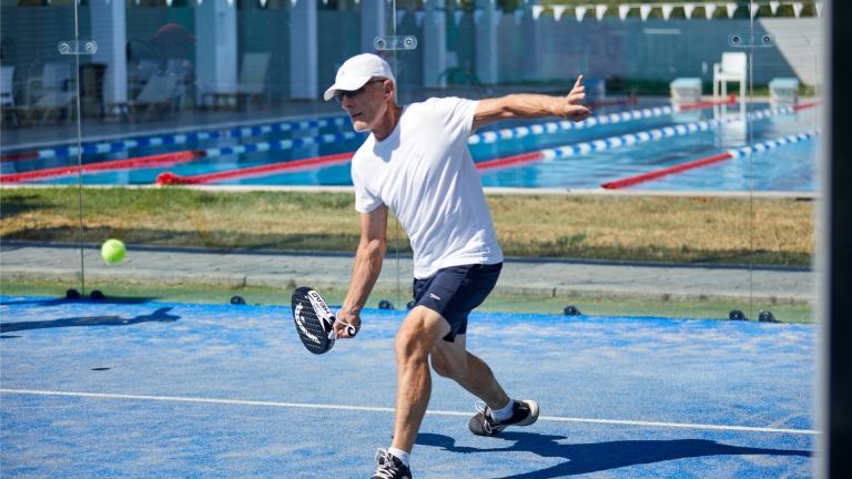 Padel tennis with lanes pool in the background at Levante Beach Club