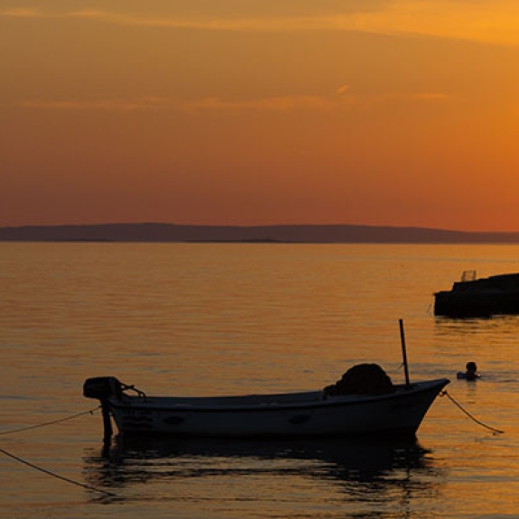 Fishing boats in water near Starigrad in Croatia at sunset