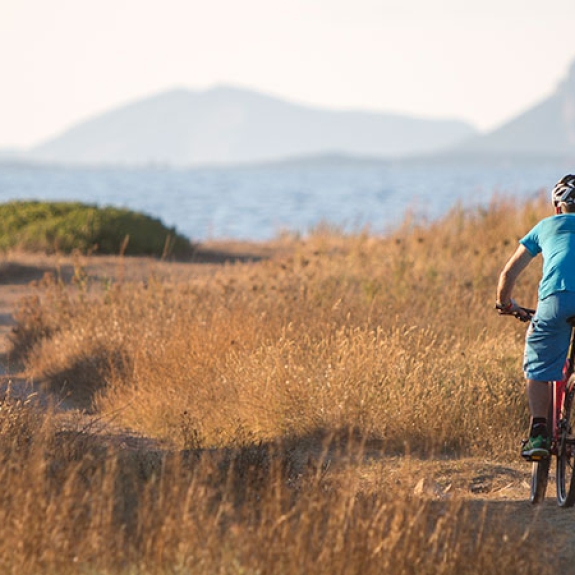 Man mountain biking by the sea in Sardinia