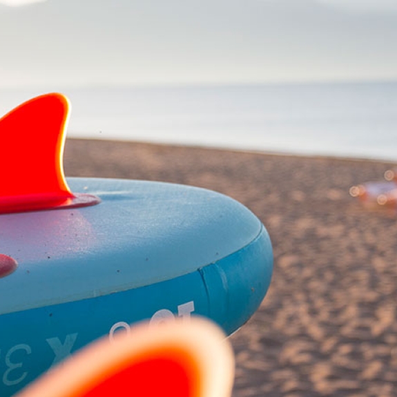 stand up paddle boards and kayaks on a beach in Greece