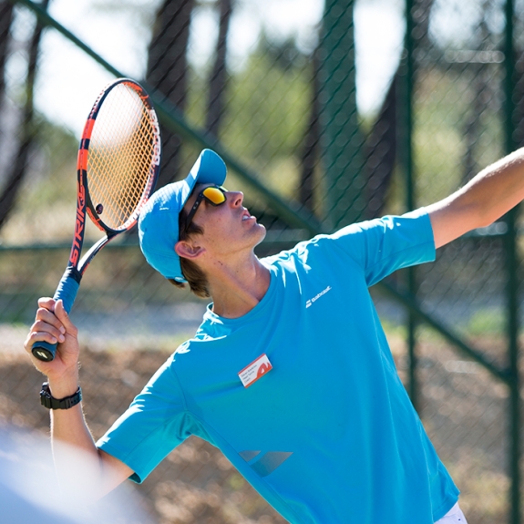 Neilson tennis coach showing how to perform a tennis serve
