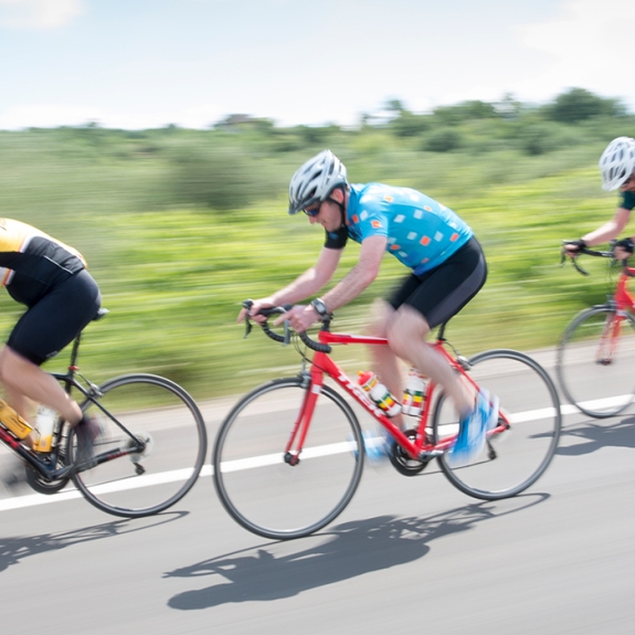 Three people road cycling