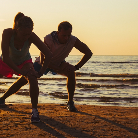 two people exercising at the beach