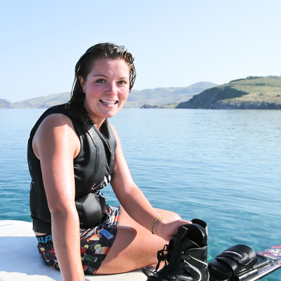 Girl on back of boat after water skiing