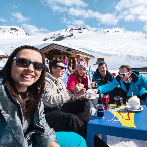 group of friends enjoying a drink in a cafe on a ski holiday