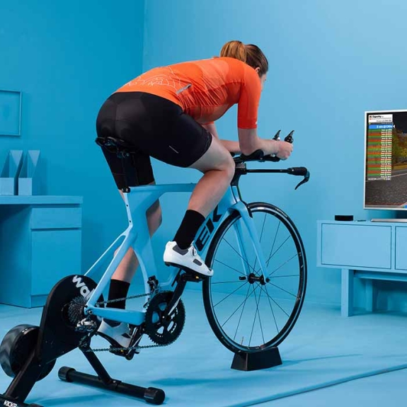 Man in living room and a static bike joining a Zwift ride