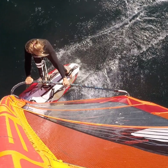 Girl windsurfing in a wetsuit