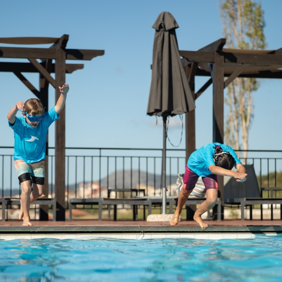 Kids jumping into a swimming pool