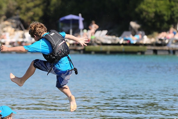 children jumping into the sea
