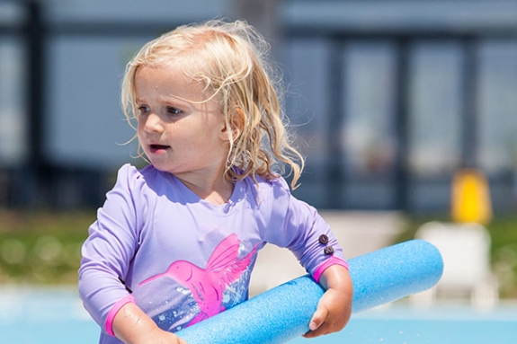 toddler playing in swimming pool