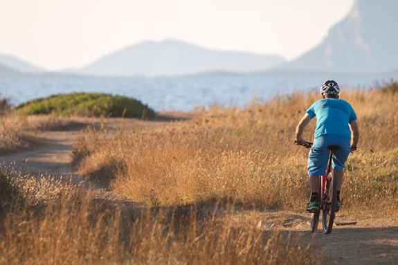 Man mountain biking by the sea in Sardinia
