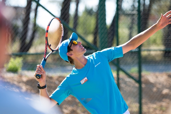 Neilson tennis coach showing how to perform a tennis serve