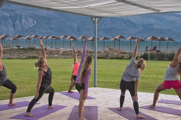 group of people doing yoga by the sea