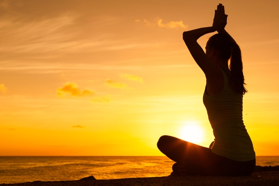 Girl meditating at sunset