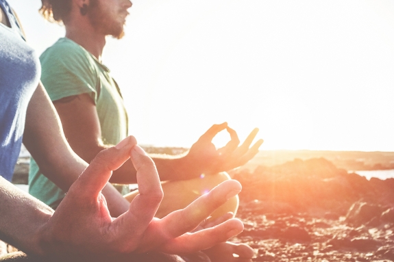 2 people doing yoga at sunset