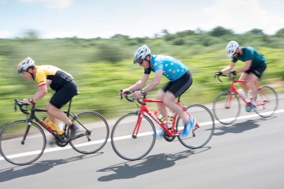 Three people road cycling