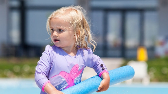 toddler playing in swimming pool