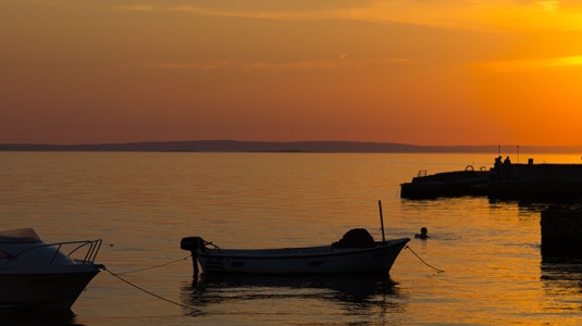 Fishing boats in water near Starigrad in Croatia at sunset