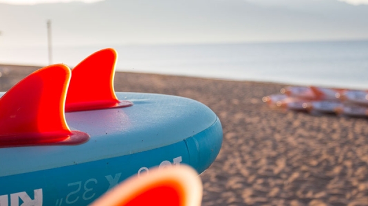 stand up paddle boards and kayaks on a beach in Greece