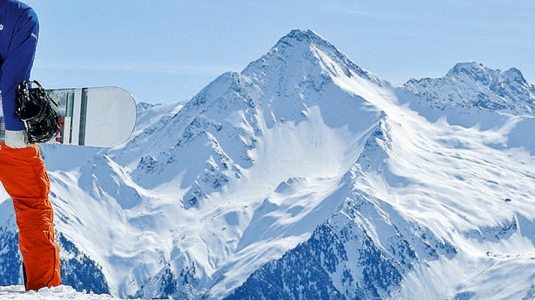 man standing holding a snowboard