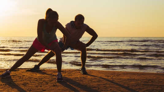 two people exercising at the beach
