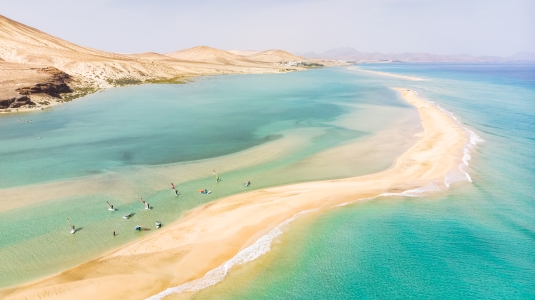 Aerial view of people windsurfing in shallow water