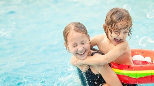 A boy and girl playing in a pool