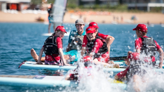 group of teenagers on stand up paddle boards