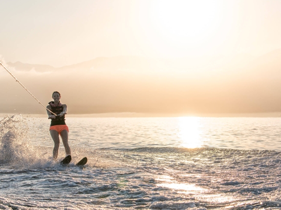 Woman water skiing at sunset