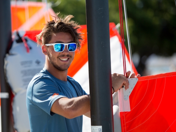 Neilson dinghy instructor hoisting a sail