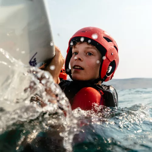 boy practising capsize in a dinghy