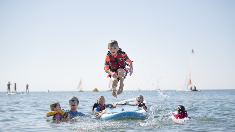 Fun with the kids' club on paddle boards at Levante Beach Club