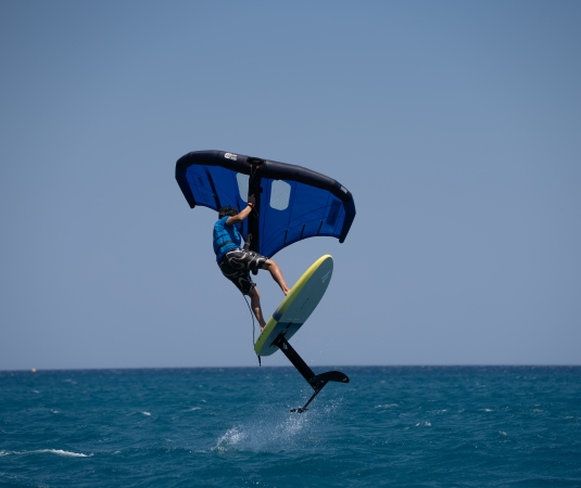   a person engaging in wing foiling on the ocean