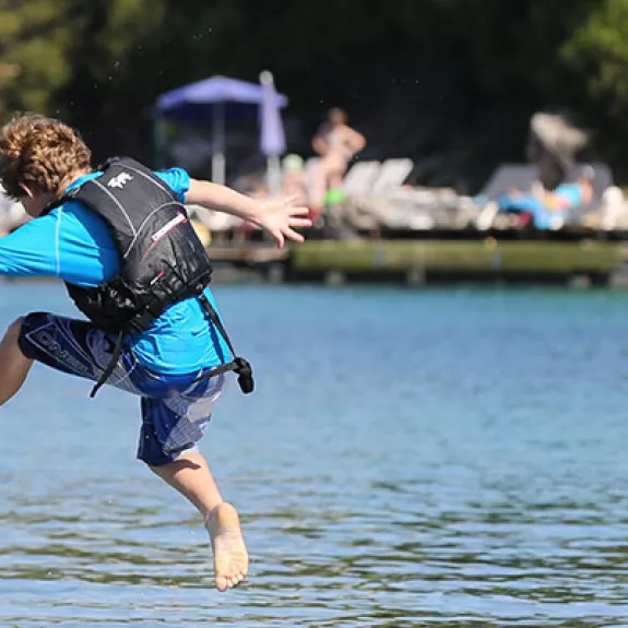 children jumping into the sea