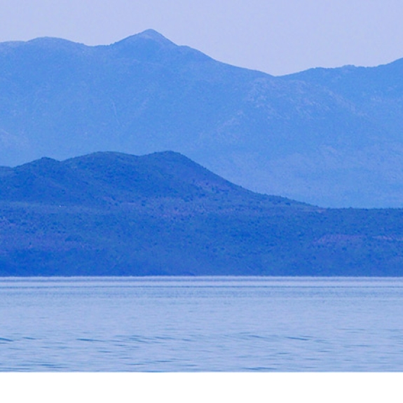 dinghy sailing in a bay in Greece
