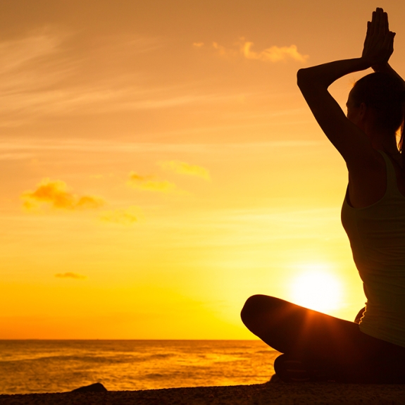 Girl meditating at sunset