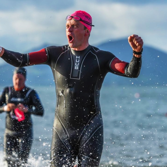 triathlete emerging from water after completing swim