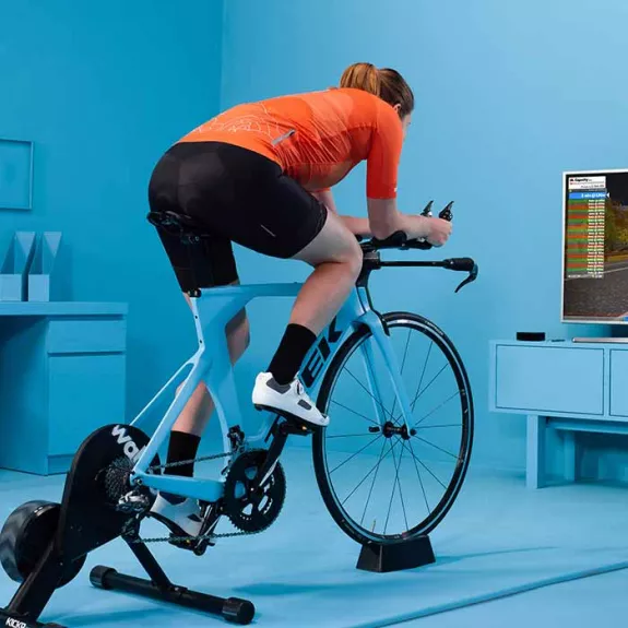 Man in living room and a static bike joining a Zwift ride