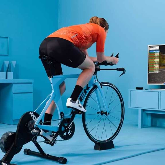 Man in living room and a static bike joining a Zwift ride