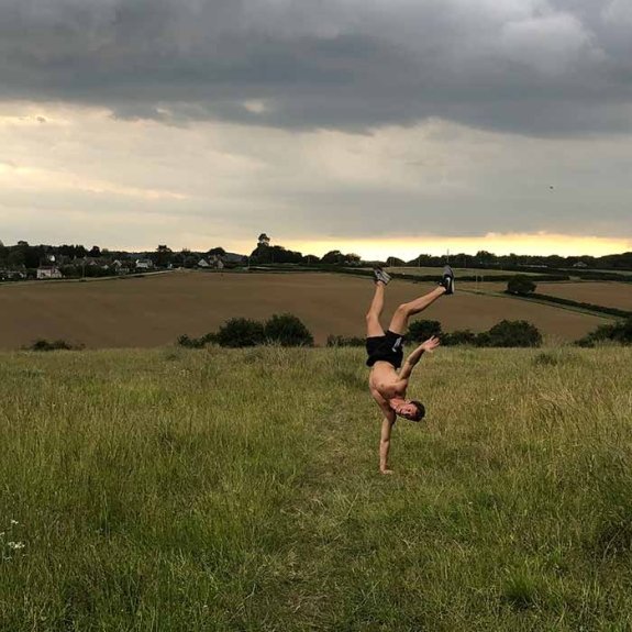 Archie doing a handstand in a field