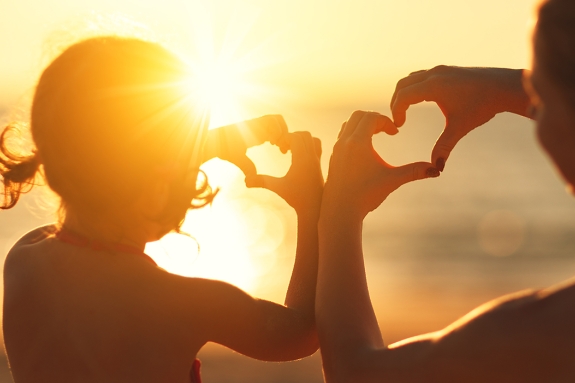 Woman and child on beach at sunset