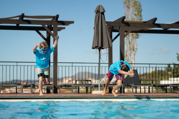 Kids jumping into a swimming pool