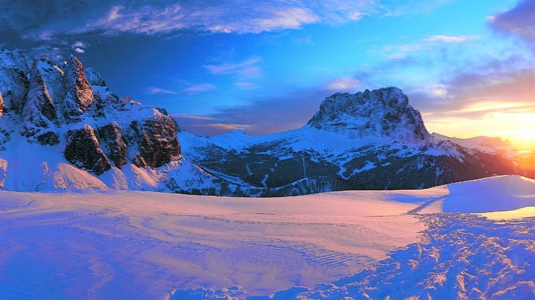 sun rise over Italian mountains covered in snow