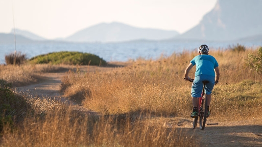 Man mountain biking by the sea in Sardinia