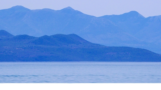 dinghy sailing in a bay in Greece